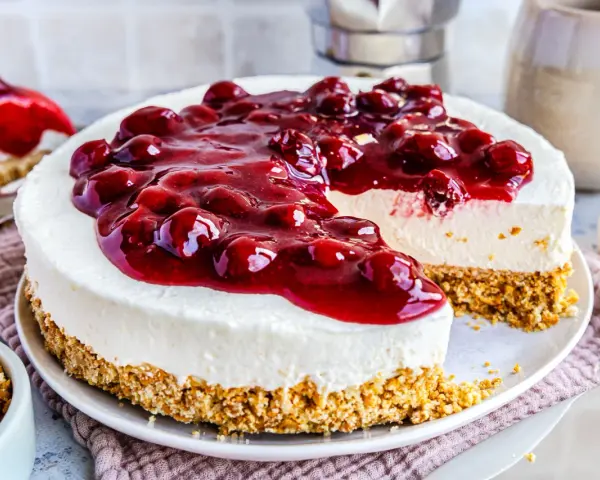 Ein köstlicher, schneller Kuchen ohne Backen mit Kirschen und cremigem Frischkäse auf Keksboden. Perfekt für heiße Tage!