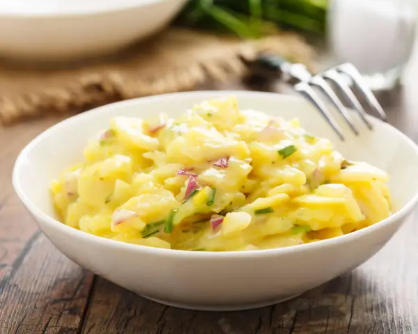 Ein cremiger Kartoffelsalat mit roten Zwiebeln und Schnittlauch, perfekt als Beilage zum Grillen.