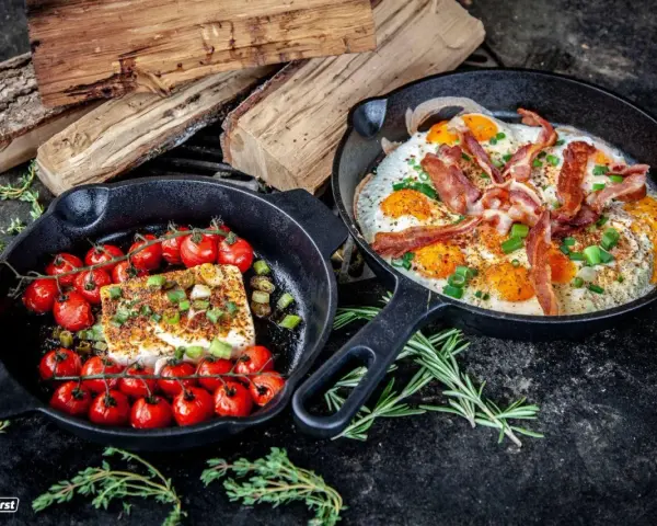 Zwei Gusseisenpfannen mit Eiern, Speck und Kirschtomaten mit Feta – perfekt für low carb grillen.