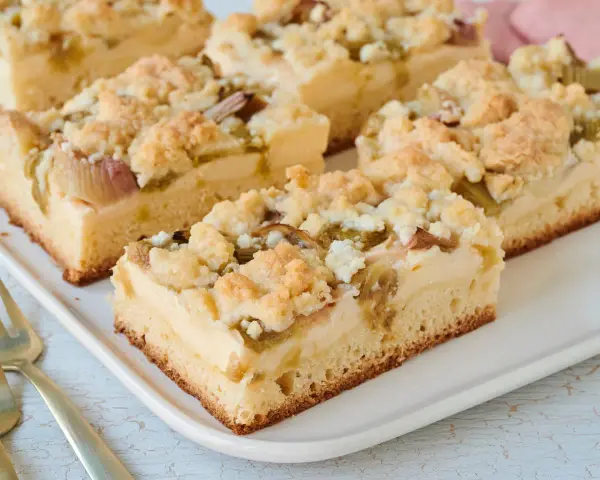 Saftiger Rhabarberkuchen mit Pudding vom Blech, bestreut mit knusprigen Streuseln. Ein Genuss für jeden Kaffeetisch!
