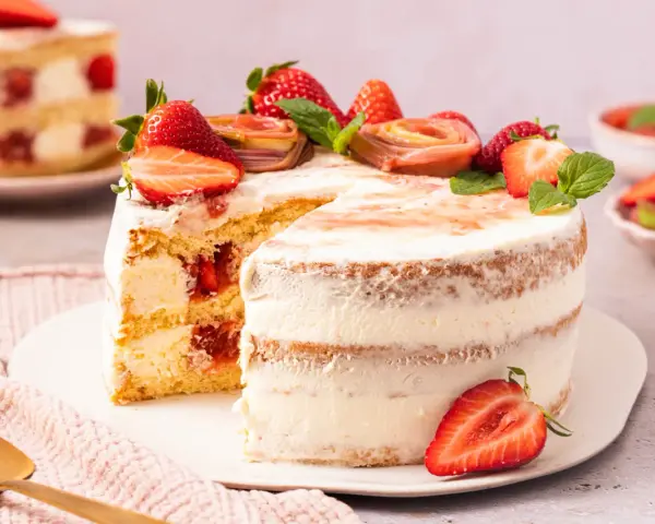 Eine köstliche Erdbeer Rhabarber Torte mit frischen Früchten und Sahne.