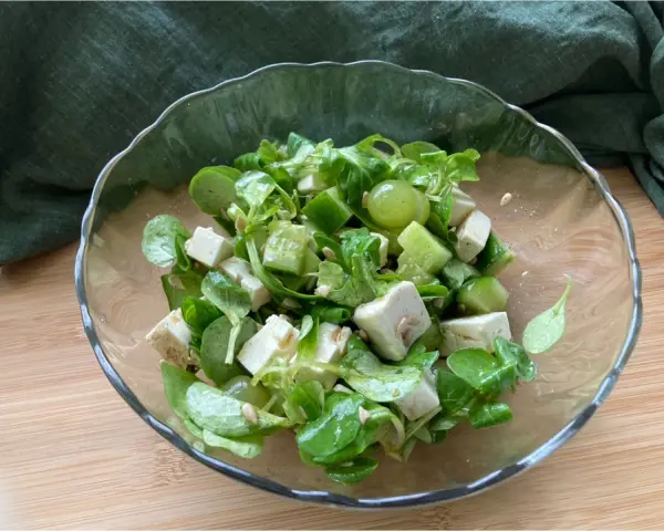 Erfrischender Salat mit grünen Weintrauben, Feta und Gurke in einer Glasschüssel.