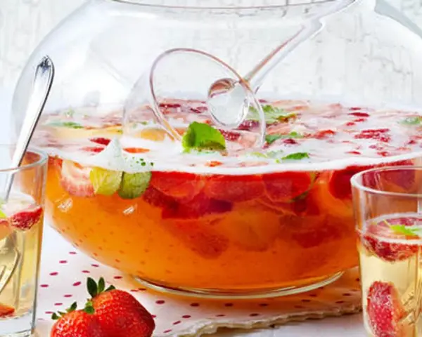 Erfrischendes Bowle-Rezept mit Erdbeeren und Minze in einer großen Glasbowle, bereit zum Servieren in Gläsern.
