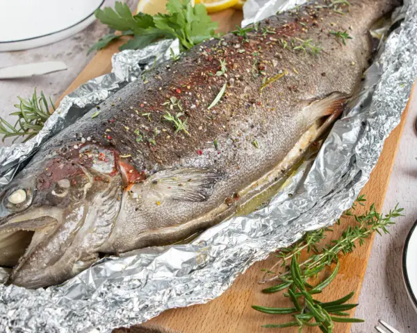Saftige Lachsforelle im Backofen, mit Kräutern und Gewürzen verfeinert, bereit zum Servieren.