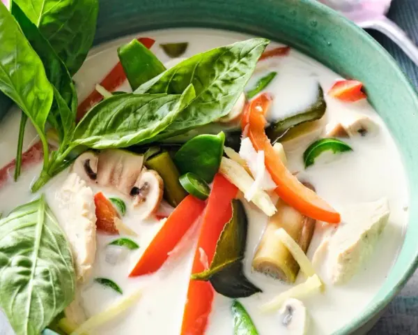 Tom Kha Gai, eine cremige Kokosmilchsuppe mit Hühnchen, Pilzen und Gemüse. Der Unterschied zu Tom Yam Gai liegt in der Kokosmilch.