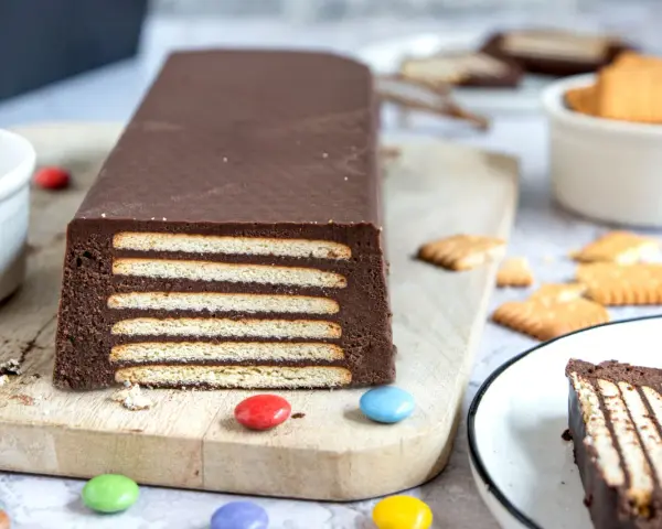 Schokoladiger Kalter Hund, Omas Rezept, geschichtet mit Keksen und Schokocreme, verziert mit bunten Smarties.