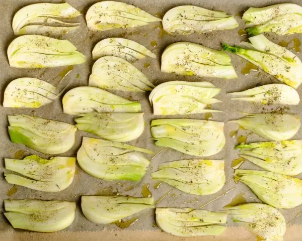 Vorbereiteter Fenchel für den Ofen, mit Olivenöl und Kräutern gewürzt, bereit für ein italienisches Gericht.