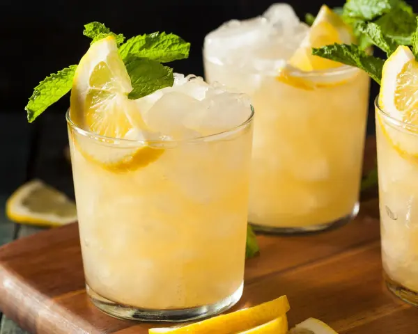 Erfrischender French 75 mit Zitrone und Minze, serviert auf Eis.