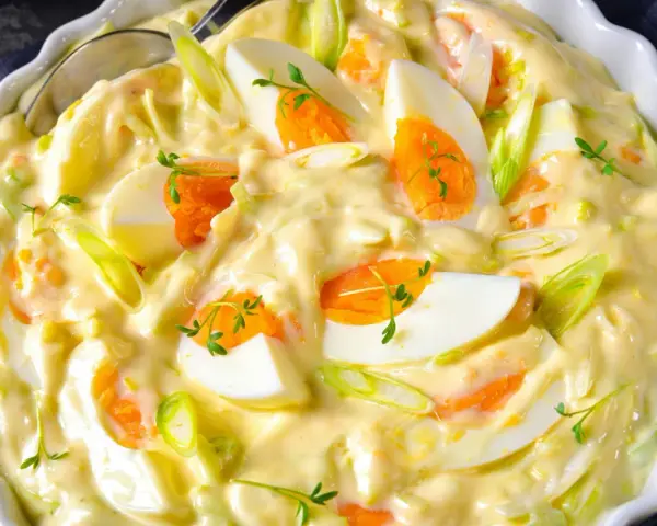 Cremiger Eiersalat mit Lauchzwiebeln und Kräutern, serviert in einer weißen Schüssel. Ein köstlicher Salat, der perfekt zu vielen Gerichten passt.