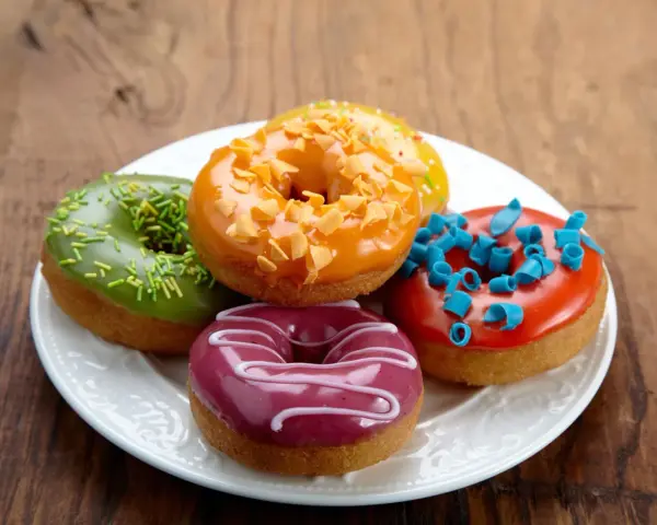 Bunte Mini Donuts mit Glasur und Streuseln, perfekt für ein schnelles Mini Donuts Rezept.