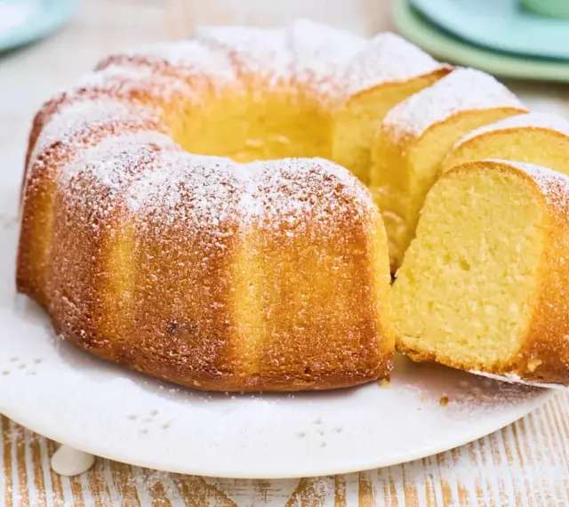 Ein goldbrauner Gugelhupf, bestäubt mit Puderzucker. Dieser Kuchen mit vielen Eiern duftet herrlich und ist bereit zum Genießen.