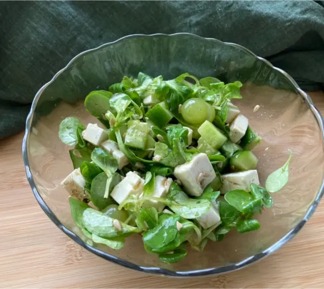 Erfrischender Salat mit grünen Weintrauben, Feta und Gurke in einer Glasschüssel.