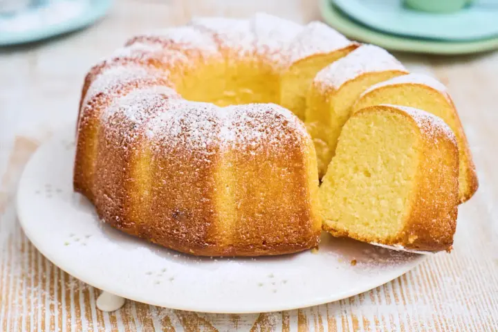Ein goldbrauner Gugelhupf, bestäubt mit Puderzucker. Dieser Kuchen mit vielen Eiern duftet herrlich und ist bereit zum Genießen.
