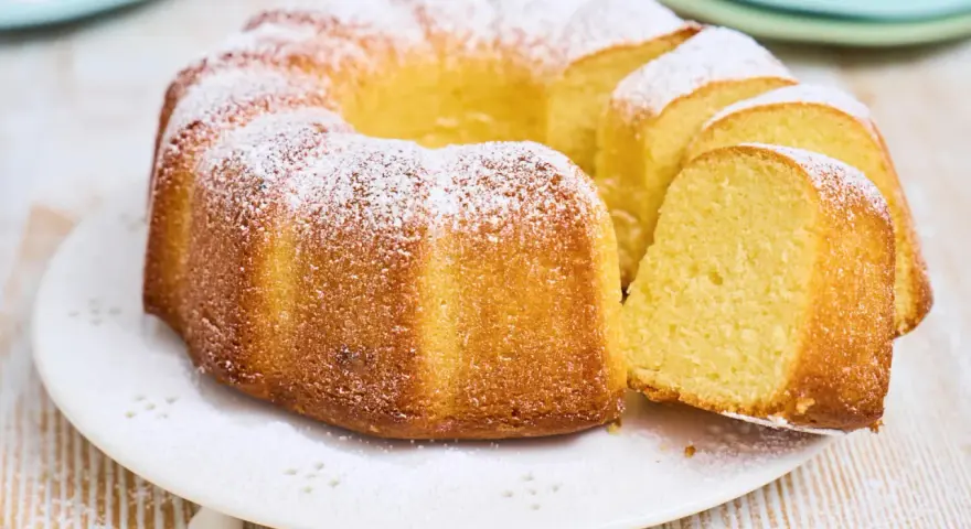 Ein goldbrauner Gugelhupf, bestäubt mit Puderzucker. Dieser Kuchen mit vielen Eiern duftet herrlich und ist bereit zum Genießen.