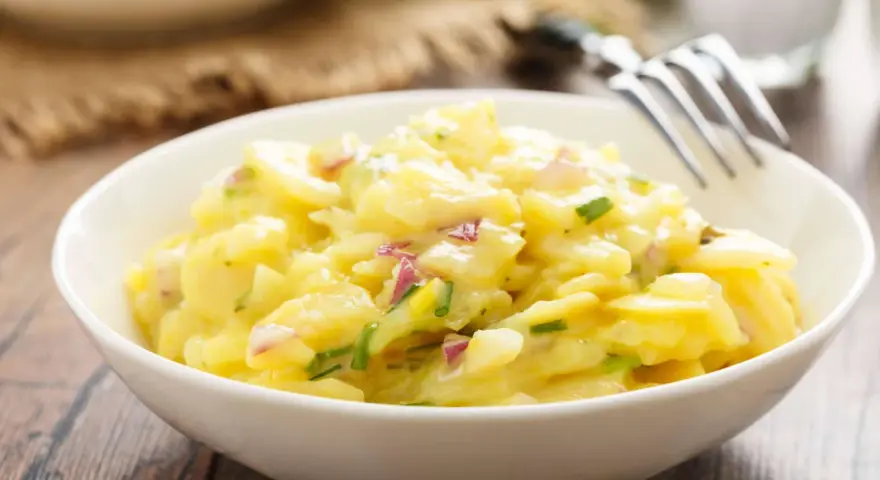 Ein cremiger Kartoffelsalat mit roten Zwiebeln und Schnittlauch, perfekt als Beilage zum Grillen.