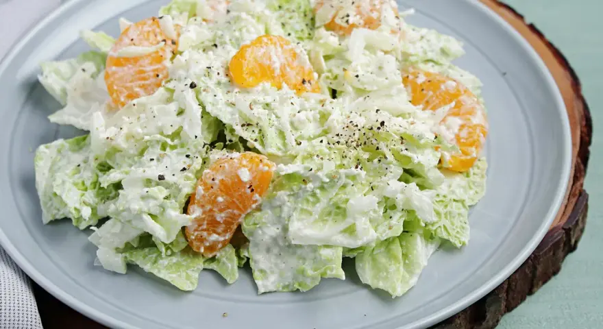 Frischer Chinakohlsalat mit saftigen Mandarinenstücken, cremig angemacht und mit Pfeffer bestreut. Ein leichter Genuss!