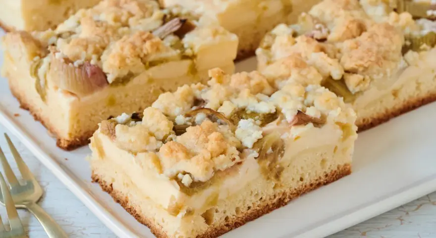 Saftiger Rhabarberkuchen mit Pudding vom Blech, bestreut mit knusprigen Streuseln. Ein Genuss für jeden Kaffeetisch!