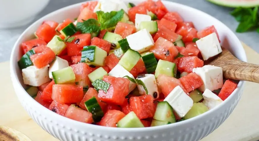 Erfrischender Wassermelone Feta Salat mit Gurke und Minze in einer weißen Schüssel, bereit zum Servieren.