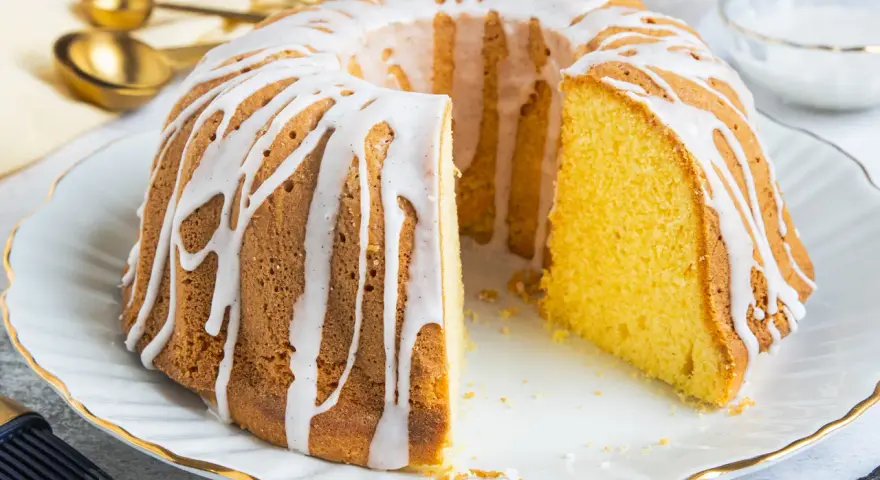 Ein saftiger Gugelhupf, verziert mit einem weißen Zuckerguss, der an Vanillepudding erinnert. Perfekt für jeden Anlass!
