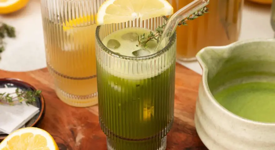 Erfrischender grüner Eistee mit Zitrone und Minze, perfekt zum Eistee selber machen. Daneben ein Glas gelber Eistee.