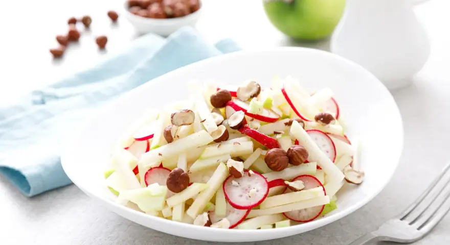 Frischer Kohlrabi-Apfel-Salat mit Radieschen und Haselnüssen, ein leichter Genuss.