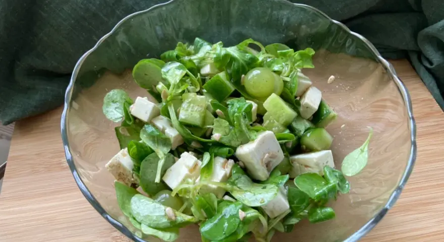 Erfrischender Salat mit grünen Weintrauben, Feta und Gurke in einer Glasschüssel.