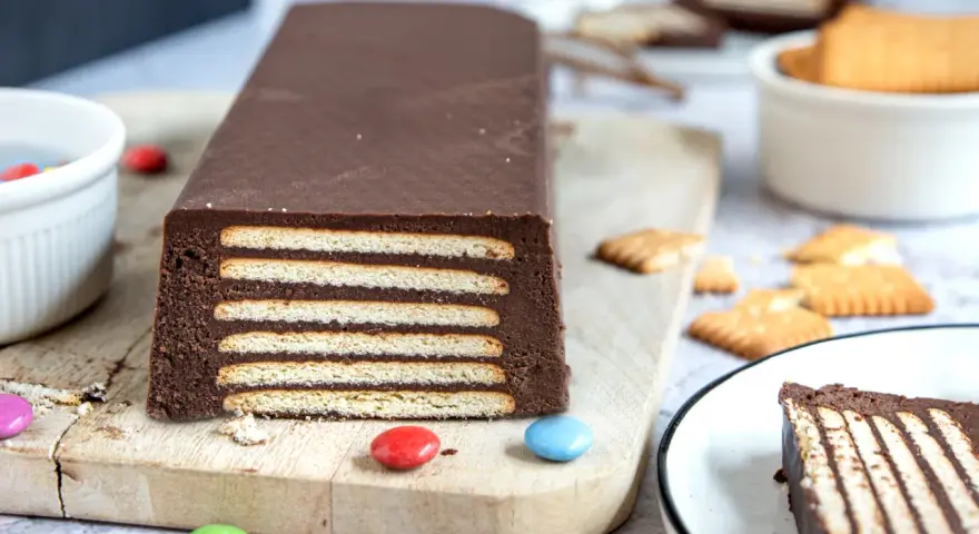 Schokoladiger Kalter Hund, Omas Rezept, geschichtet mit Keksen und Schokocreme, verziert mit bunten Smarties.