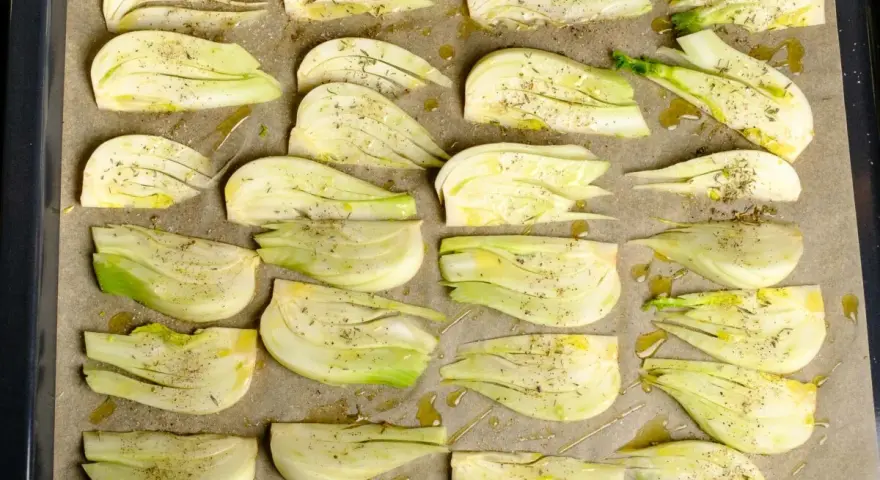 Vorbereiteter Fenchel für den Ofen, mit Olivenöl und Kräutern gewürzt, bereit für ein italienisches Gericht.