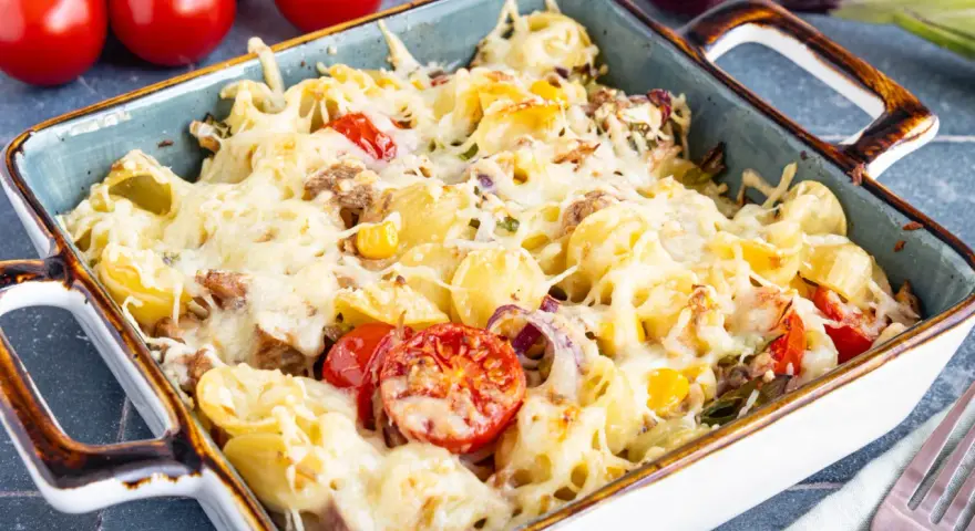 Herzhafter Nudel Thunfisch Auflauf mit geschmolzenem Käse, Tomaten und Zwiebeln, bereit zum Servieren.