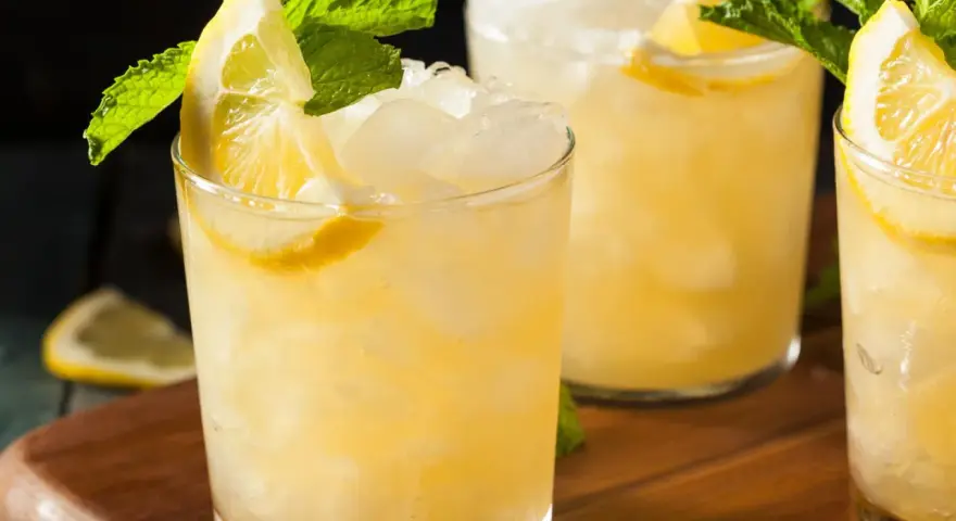 Erfrischender French 75 mit Zitrone und Minze, serviert auf Eis.