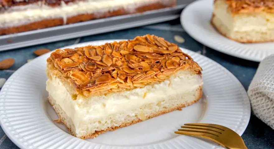 Ein Stück Bienenstich ohne Hefe mit cremiger Füllung und karamellisierten Mandeln. Ein köstliches Rezept für jeden Anlass.