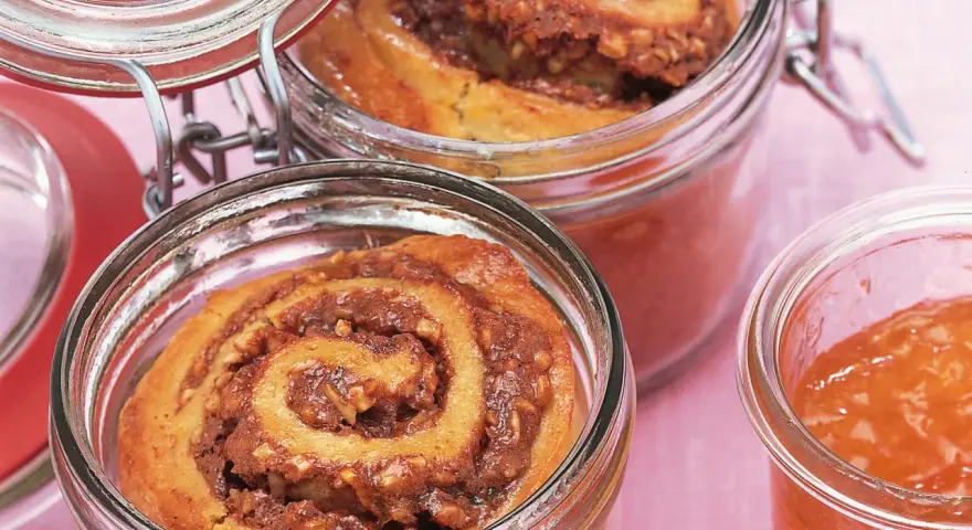 Zwei Gläser mit leckerem Kuchen im Glas, gefüllt mit Zimt-Nuss-Füllung und Marmelade.