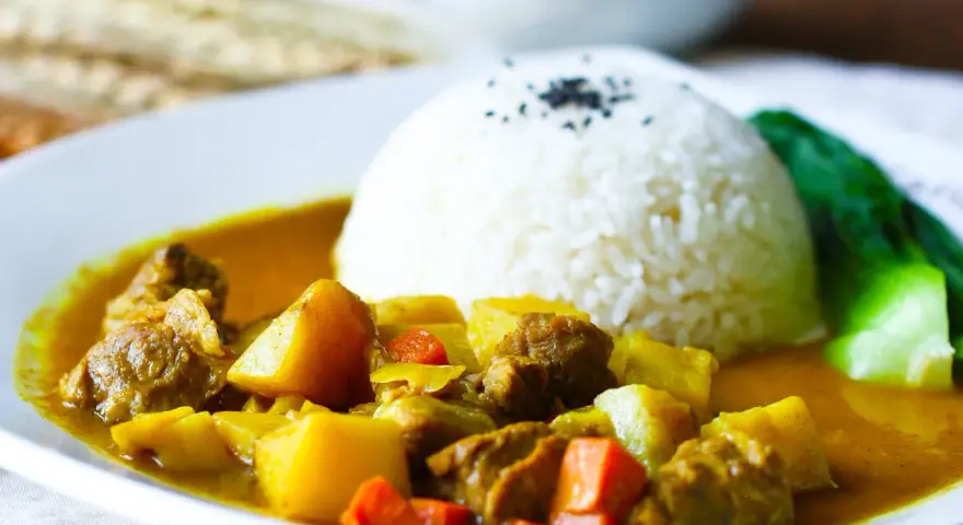 Ein Teller mit Reis und einem herzhaften Curry, das an seine Ursprünge in Indien erinnert.
