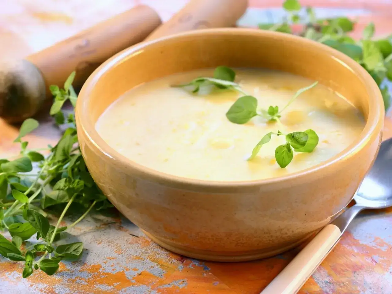 Eine dampfende Sch&uuml;ssel cremige Kartoffelsuppe mit Sahne, garniert mit frischen Kr&auml;utern. Perfekt f&uuml;r kalte Tage.