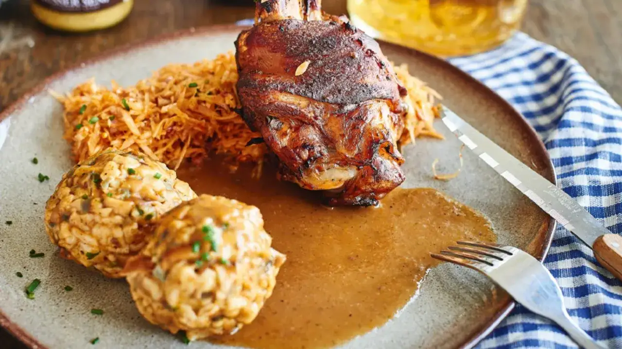 Knuspriger Schweinebraten mit Klößen und Krautsalat – ein Klassiker der deutschen Gerichte.