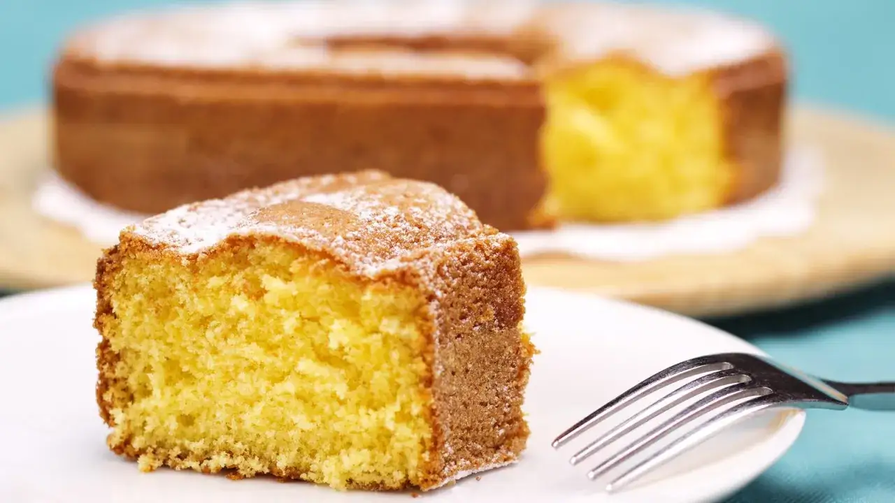 Ein saftiger Kuchen mit Puddingpulver, best&auml;ubt mit Puderzucker, wartet auf dem Teller.