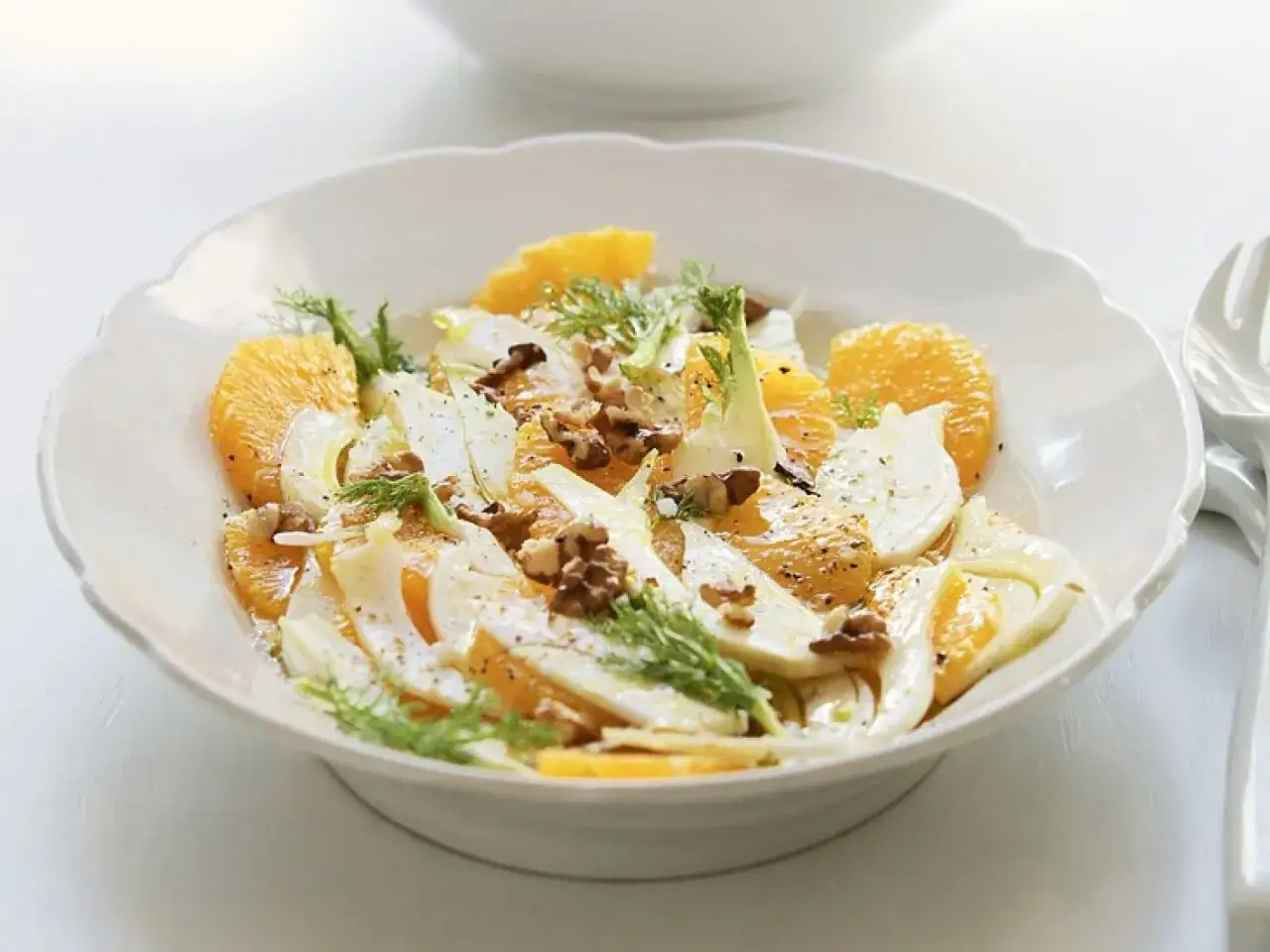Erfrischender Fenchel-Orangen-Salat mit Walnüssen, garniert mit Dill.