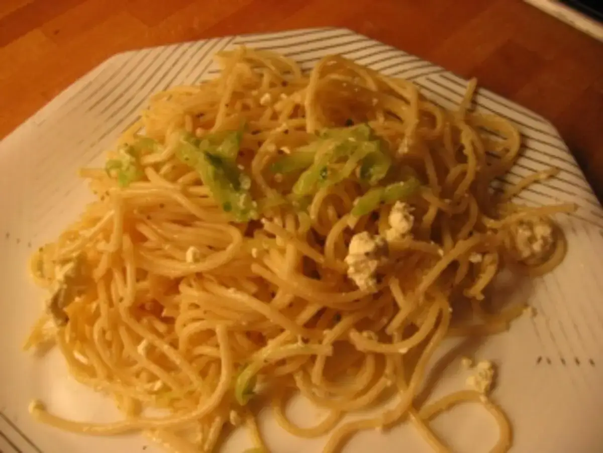 Ein Teller mit Spaghettisalat mit Knoblauch, Zucchini und Feta.