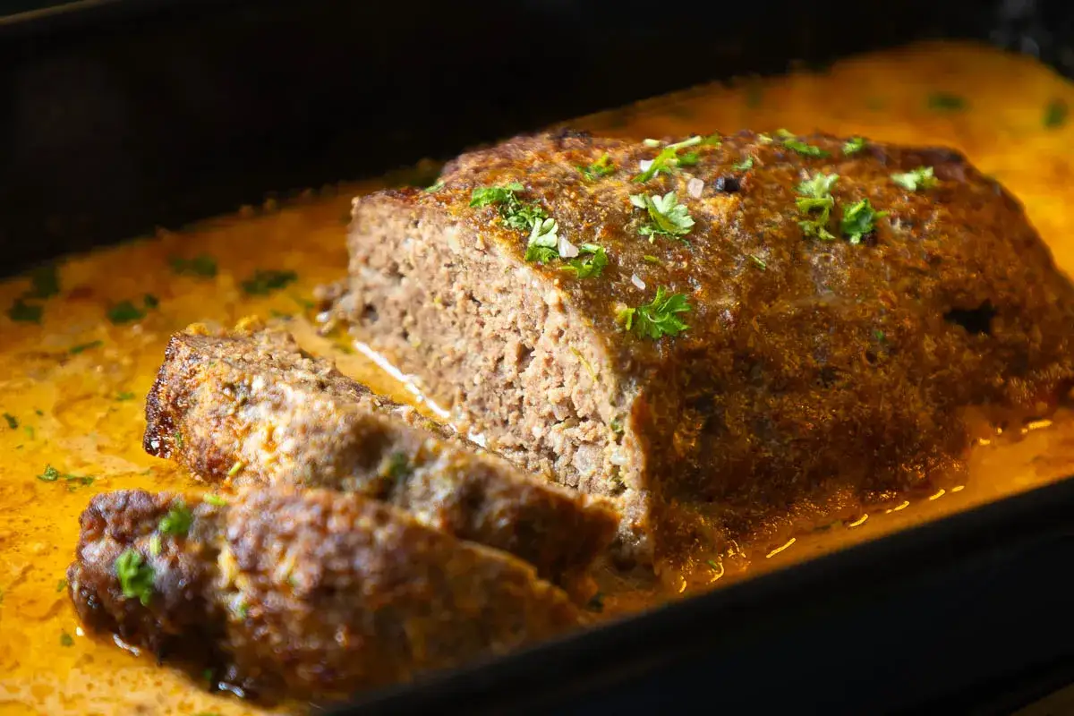 Saftiger Hackbraten in einer cremigen Sauce, garniert mit Petersilie. Die Frage 