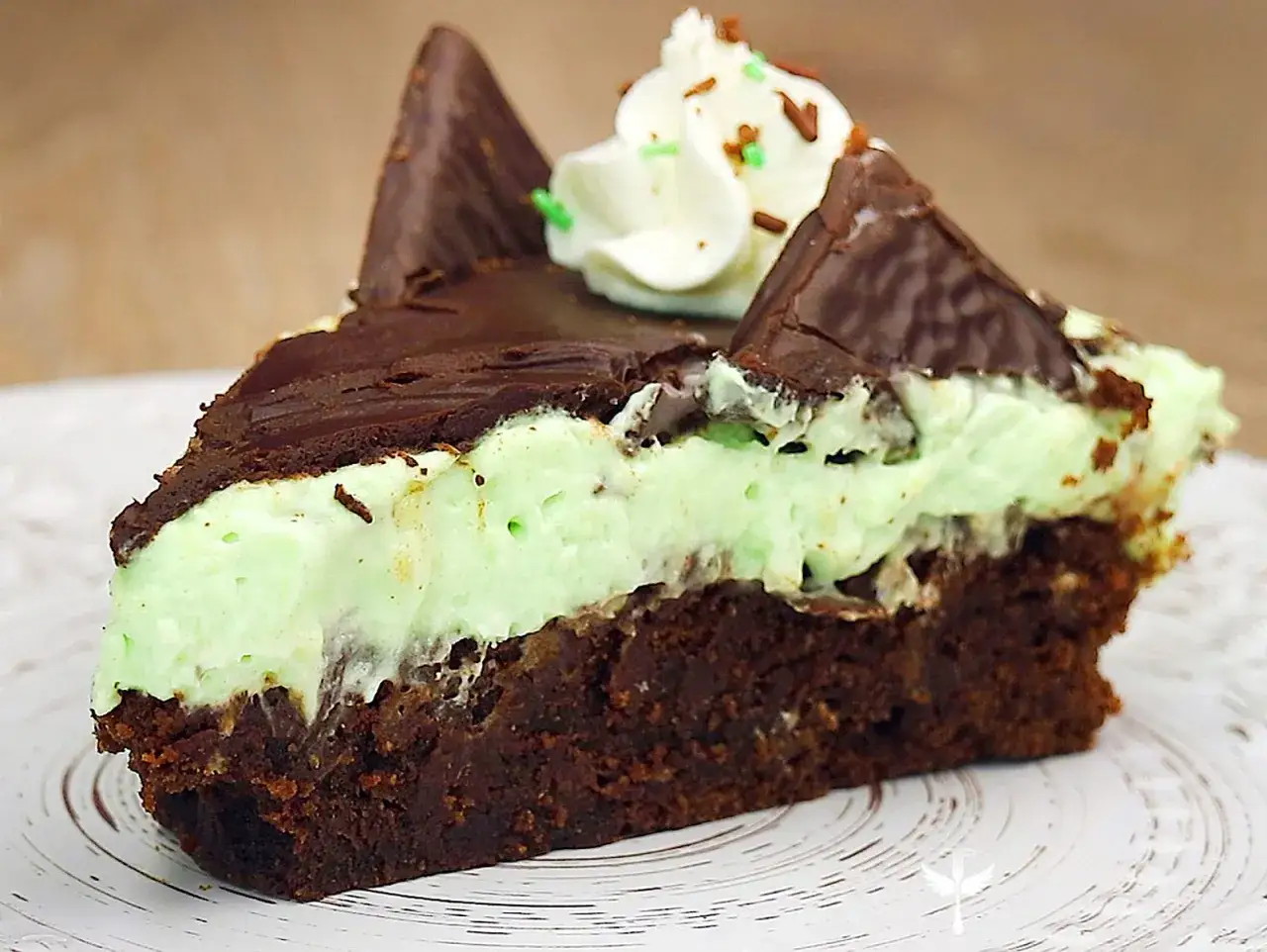 Ein St&uuml;ck After Eight Kuchen mit Schokoladenboden, Minzcreme und Schokost&uuml;ckchen.