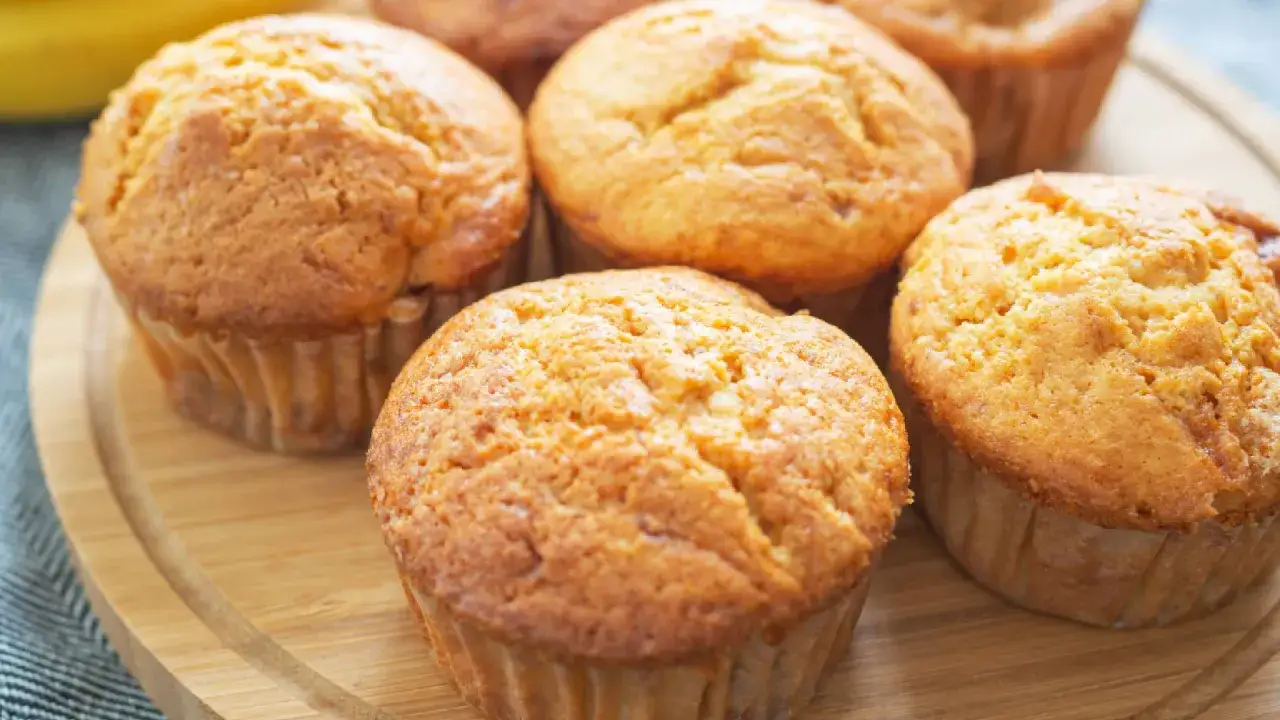Saftige Bananen Quark Muffins auf einem Holzbrett, bereit zum Genie&szlig;en.