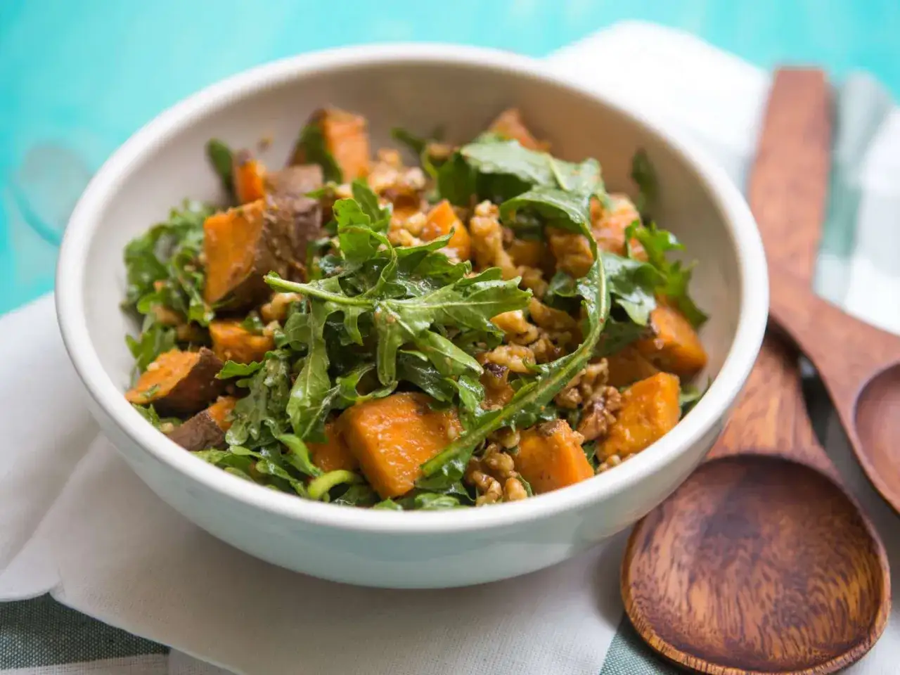 Warmer Rucola-Salat mit Süßkartoffelwürfeln und Walnüssen. Ein köstliches Gericht, das sich perfekt für Rucola Rezepte warm eignet.