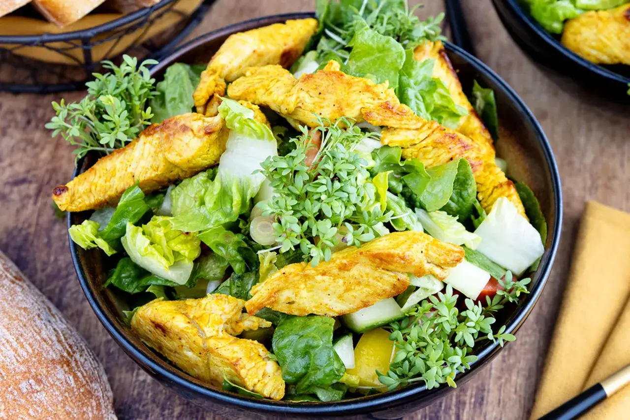 Ein frischer Salat mit knackigem Gr&uuml;n, Gurken und gelben Paprikast&uuml;cken, garniert mit w&uuml;rzigen Putenstreifen und Kresse.