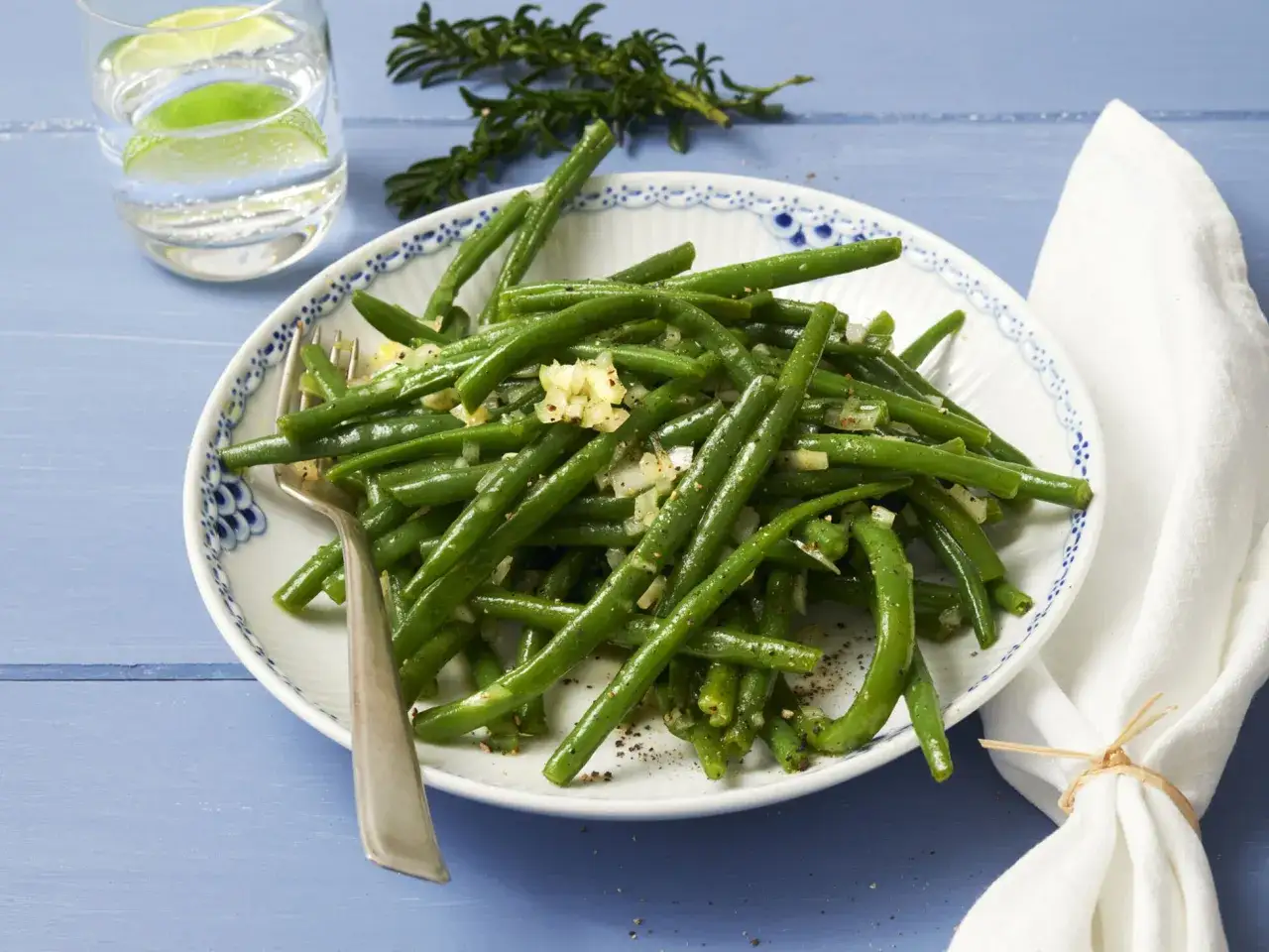 Frischer Bohnensalat, wie ihn Oma zubereitet. Gr&uuml;ne Bohnen mit Knoblauch und Zwiebeln, garniert mit Rosmarin.