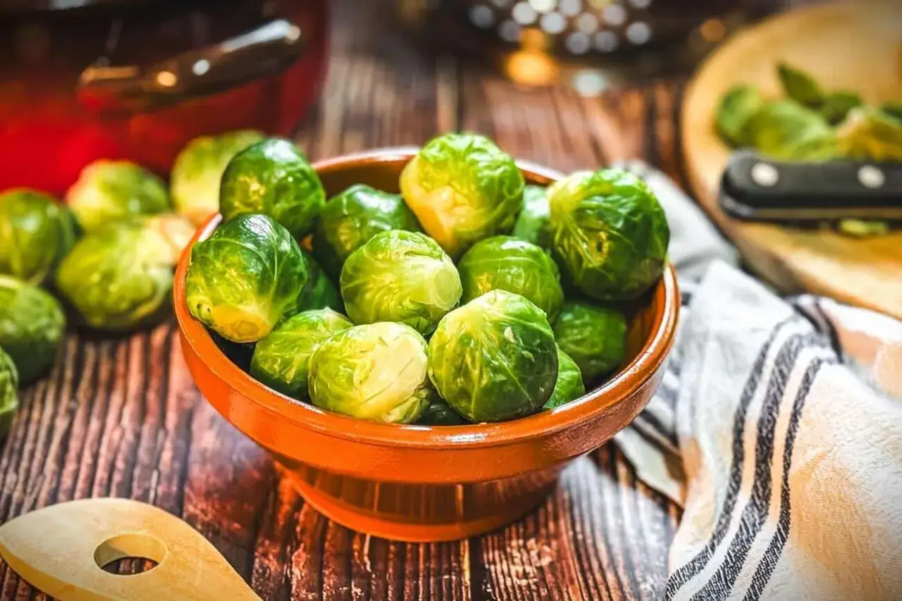 Frischer Rosenkohl in einer Schale, bereit, wie Oma ihn zubereiten w&uuml;rde. Ein Holzl&ouml;ffel liegt daneben.