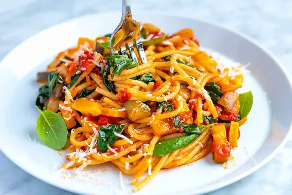 Eine Gabel nimmt eine Portion dieser k&ouml;stlichen italienischen Pasta mit Gem&uuml;se auf. Perfekt f&uuml;r vegetarische Pasta Rezepte.