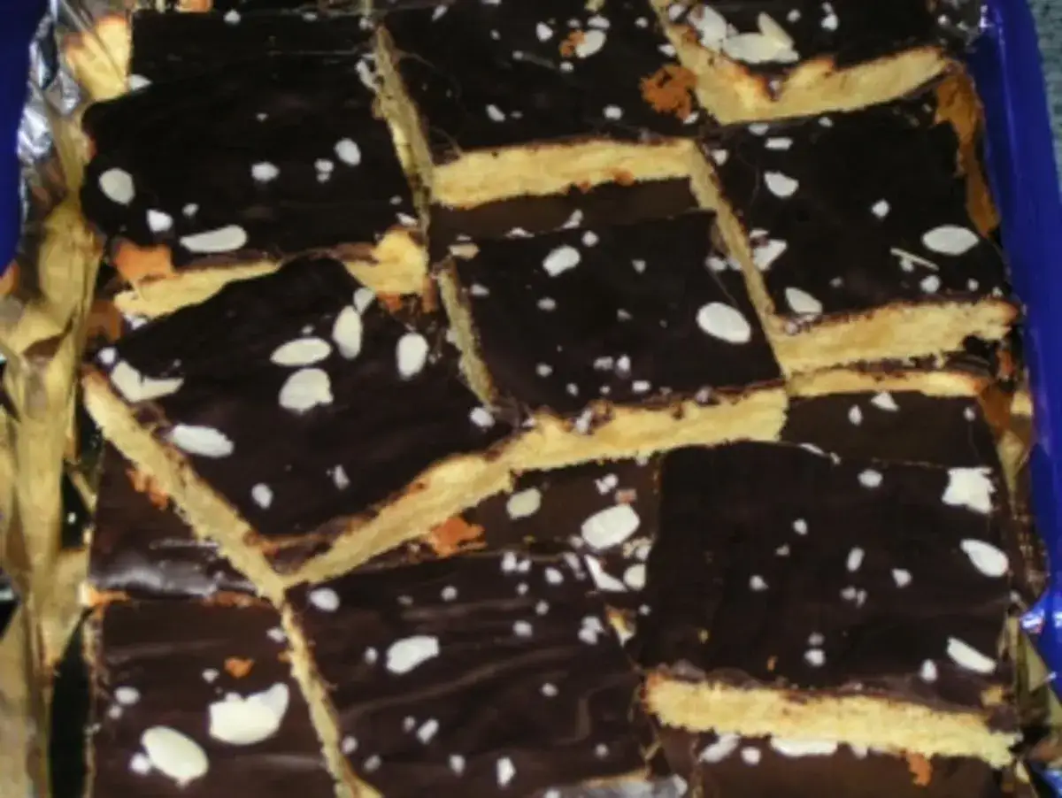 Schoko-Zitronen-Kuchenst&uuml;cke mit dunkler Schokoladenglasur und Mandelbl&auml;ttchen. Ein k&ouml;stlicher Genuss!