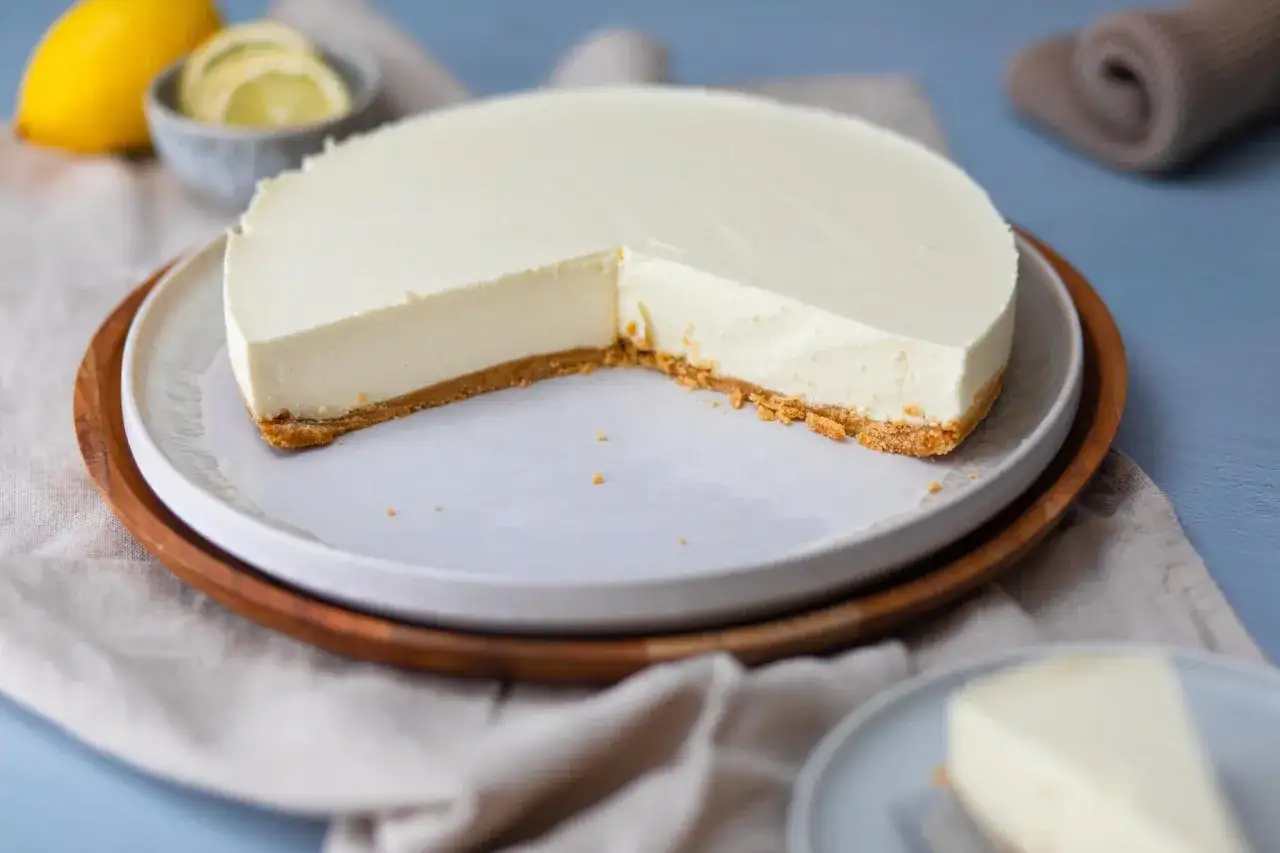 Eine cremige Philadelphia Torte Zitrone mit einem knusprigen Boden, garniert mit Zitronenscheiben.