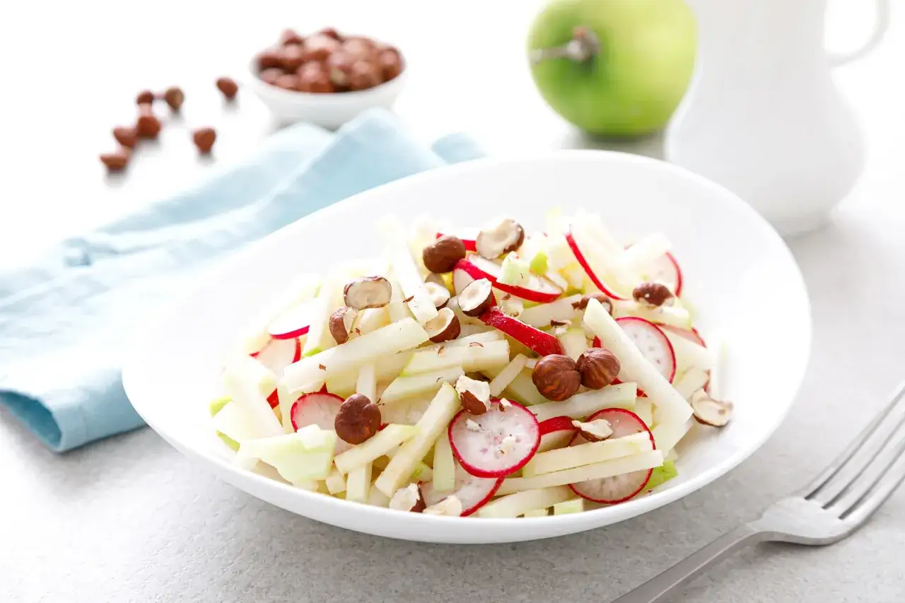 Frischer Kohlrabi Apfel Salat mit Radieschen und Haseln&uuml;ssen, garniert mit knackigen N&uuml;ssen.