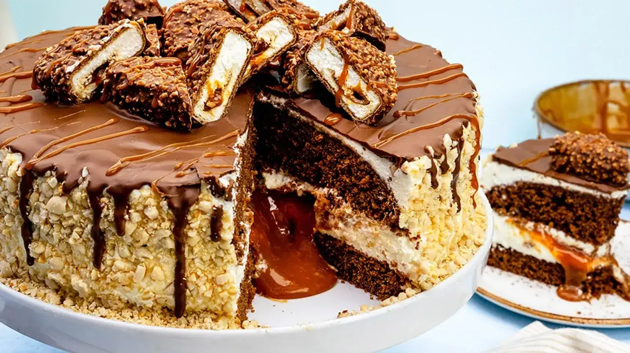 Ein saftiger maxi king kuchen mit Schokoladenglasur, Karamellf&uuml;llung und N&uuml;ssen. Ein St&uuml;ck davon ist auf einem Teller angerichtet.